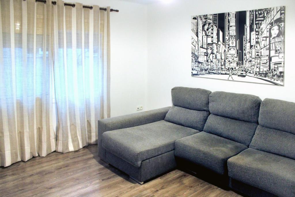 un soggiorno con divano e sedia di ACOGEDOR APARTAMENTO CERCA DE BARCELONA a Mollet del Vallès