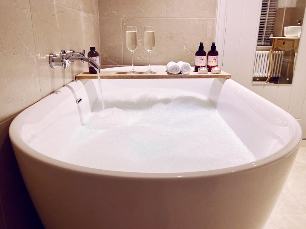 a bath tub with a water faucet in a bathroom at Olif in Betws-y-coed