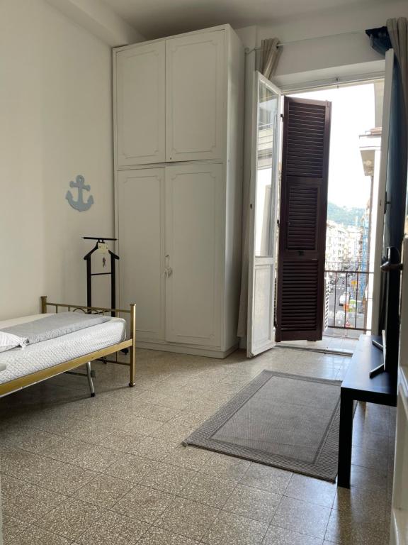 um quarto com uma cama e uma porta para uma varanda em Carpenino's home em La Spezia