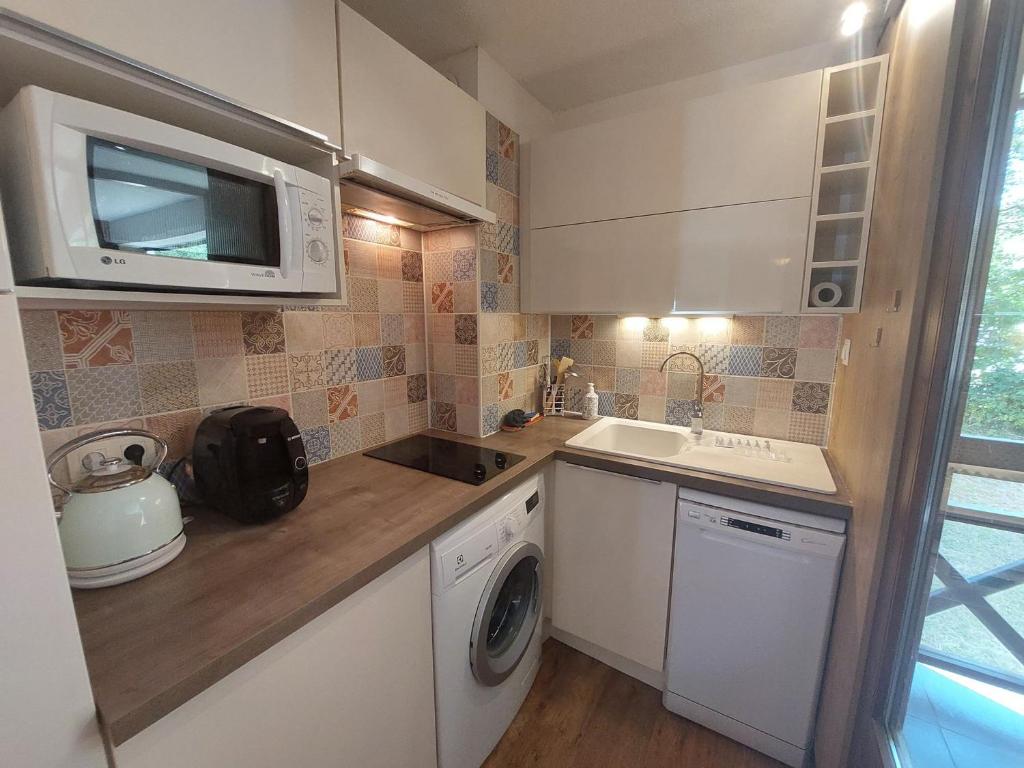 Il comprend une petite cuisine équipée d'un lave-linge et d'un four micro-ondes. dans l'établissement Studio à Brides-les-Bains avec Balcon, Parking & Wifi – 4 Pers - FR-1-512-274, à Brides-les-Bains