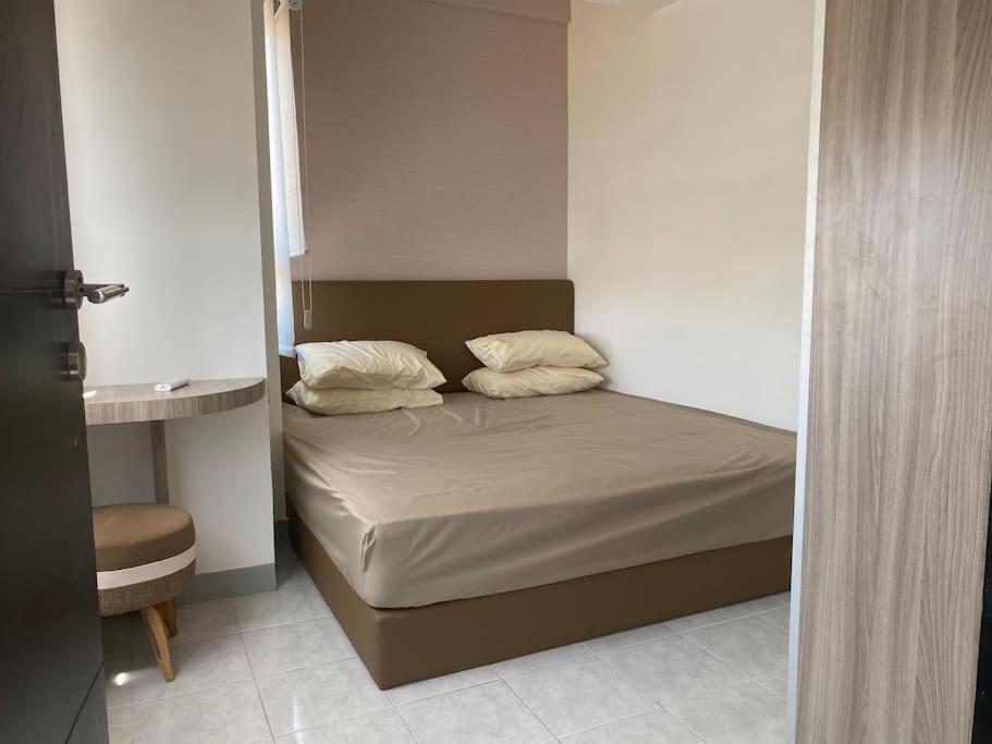 een slaapkamer met een bed met 2 kussens erop bij Apartemen Purimas - Sekai Unit in Surabaya