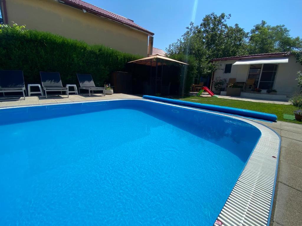 a large blue swimming pool in a yard at Casa MateiAna in Eforie Nord
