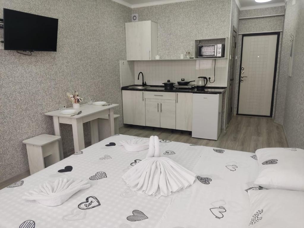 um quarto com uma cama grande e uma cozinha em Студия №2-65 LifeHouseAlmaty в ЖК Теремки-2 em Almaty