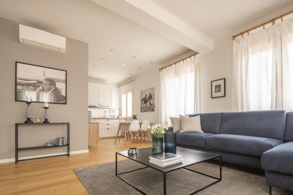 sala de estar con sofá azul y mesa en Santa Croce Design Apartment R&R, en Venecia