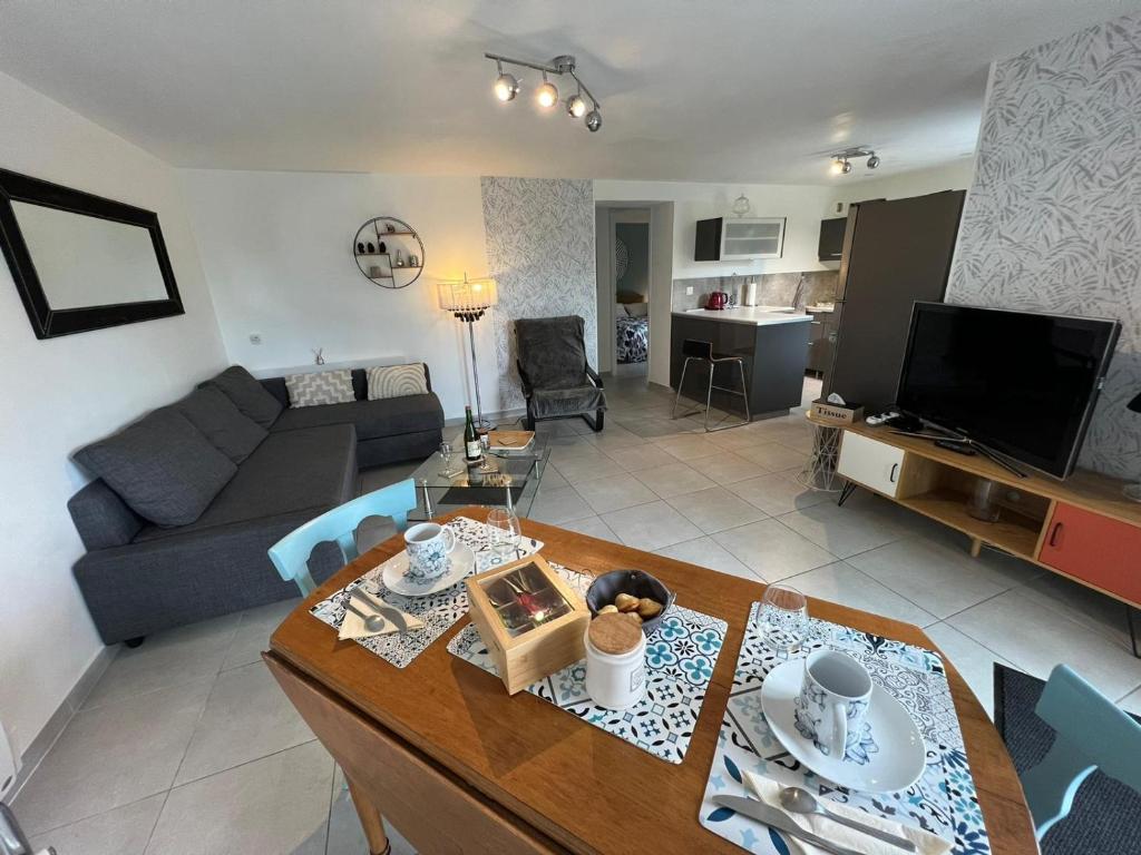 una sala de estar con un sofá y una mesa en Appart Terre & Mer Deauville, en Bonneville-sur-Touques