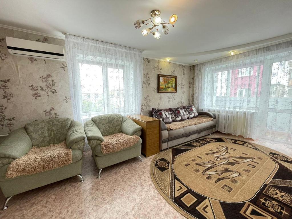 a living room with two couches and a table at 1 комнатная квартира в центре in Petropavlovsk