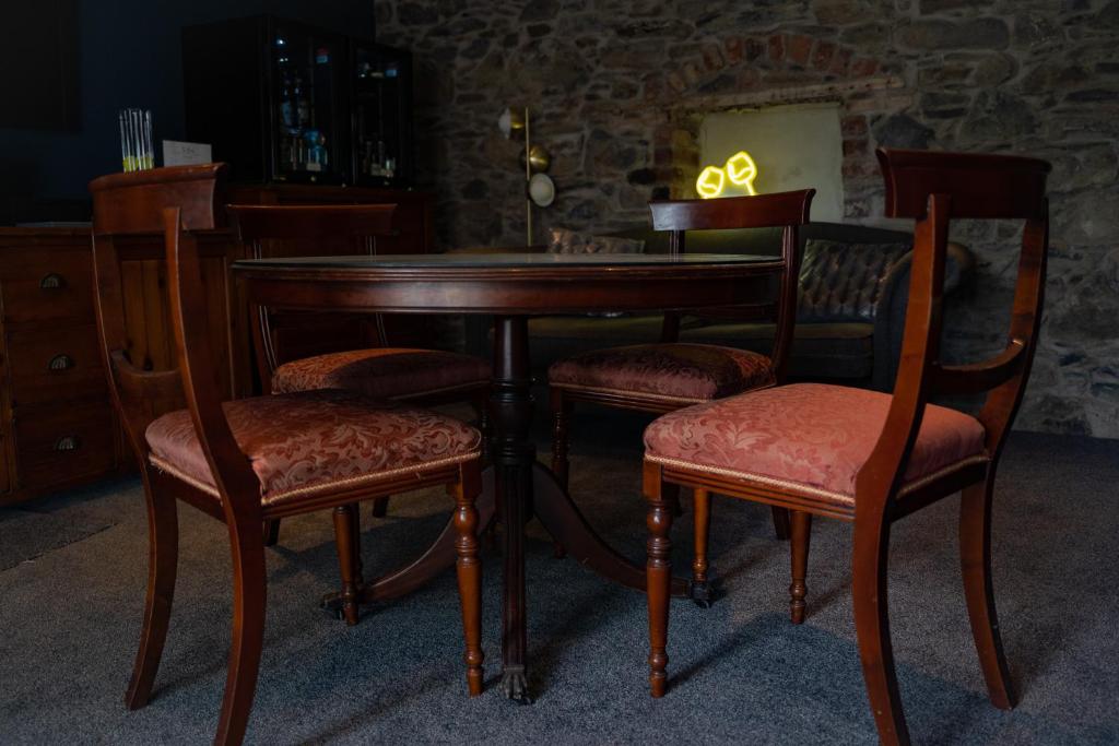 a wooden table with two chairs and a wooden table with at The Briers Country House in Newcastle