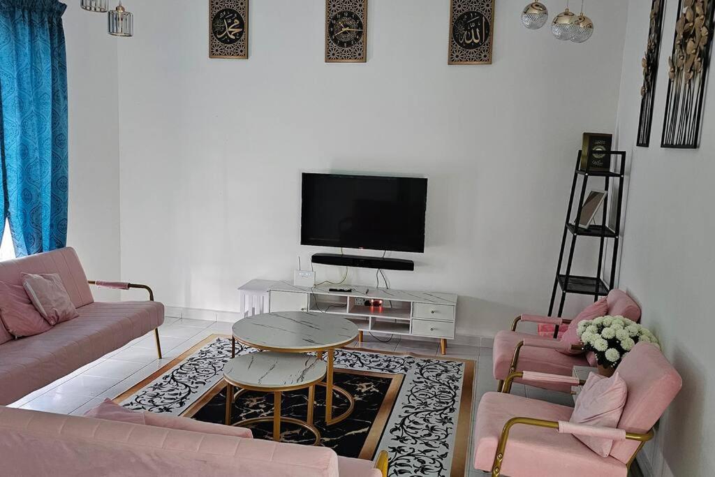甘孟的住宿－Nafisa 3 Homestay，客厅配有粉色家具和平面电视