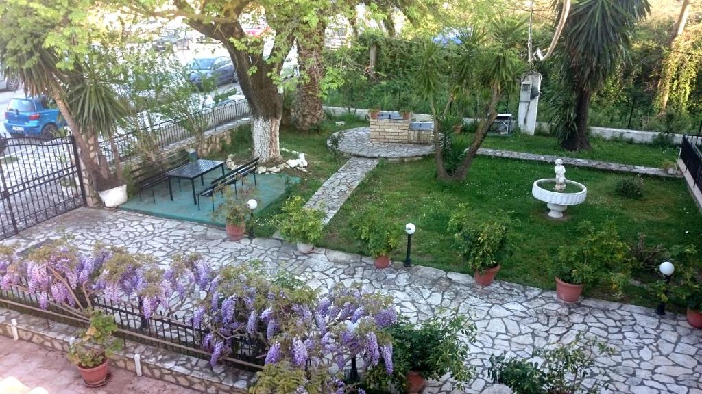 a garden with purple flowers and a fountain at Maritsas Apartments in Roda
