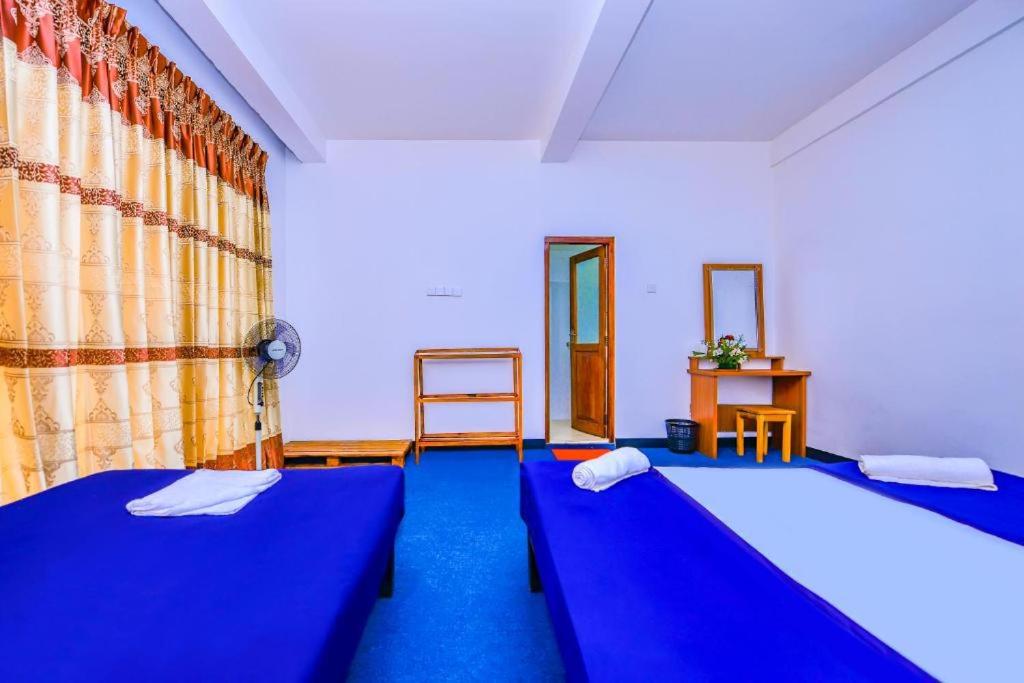 2 Betten in einem Zimmer mit blauem Teppich in der Unterkunft Ella Rock Heaven in Ella