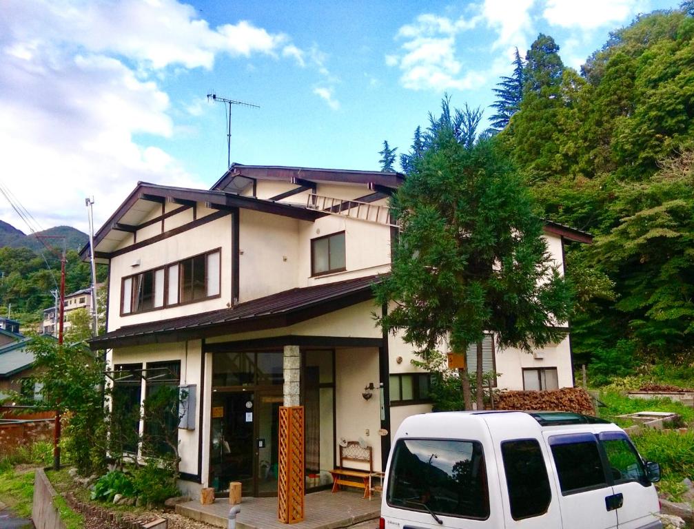 una furgoneta blanca estacionada frente a una casa en Matsuo House - Max 4 person Room Aki en Zao Onsen
