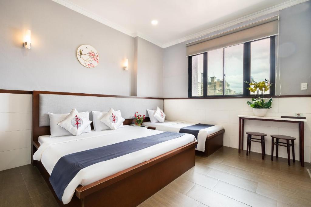 een hotelkamer met een bed en een bureau bij Văn Hoa Hotel in Ho Chi Minh-stad