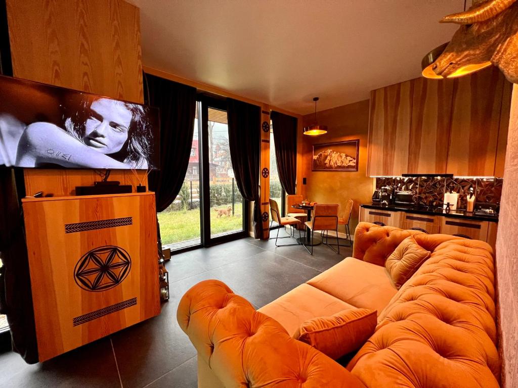 a living room with a couch and a tv at Crusoe Zakopane in Zakopane