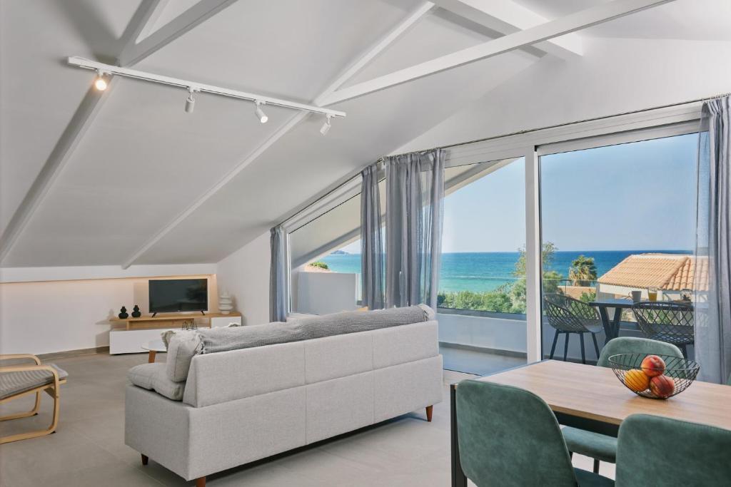 a living room with a couch and a view of the ocean at Sofita Sea View Apartment in Argassi