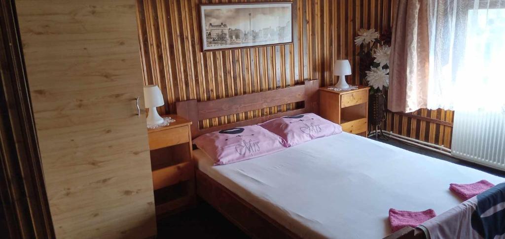 a bedroom with a bed with pink pillows on it at Hostel INTIM 95 RON in Bîrlad
