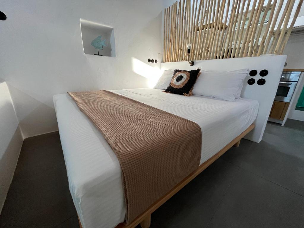 una camera da letto con un letto grande con testiera in legno di White Coral a Klima