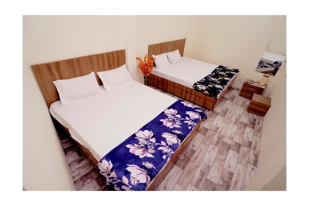 two beds in a small room with at Rajdarshan Hotel in Ujjain