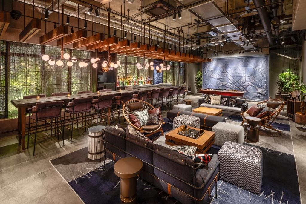 a lobby with a bar and a couch and tables at THE LIVELY TOKYO AZABUJUBAN in Tokyo