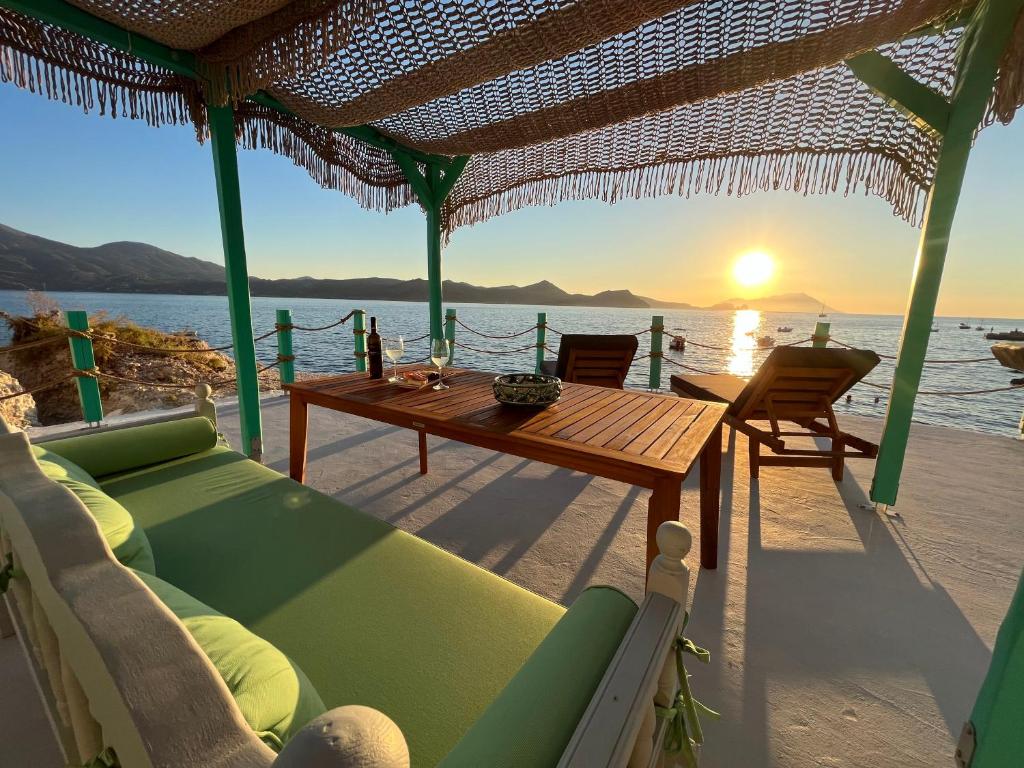 ein Haus am Strand mit einem Tisch und Stühlen in der Unterkunft White Coral in Klima