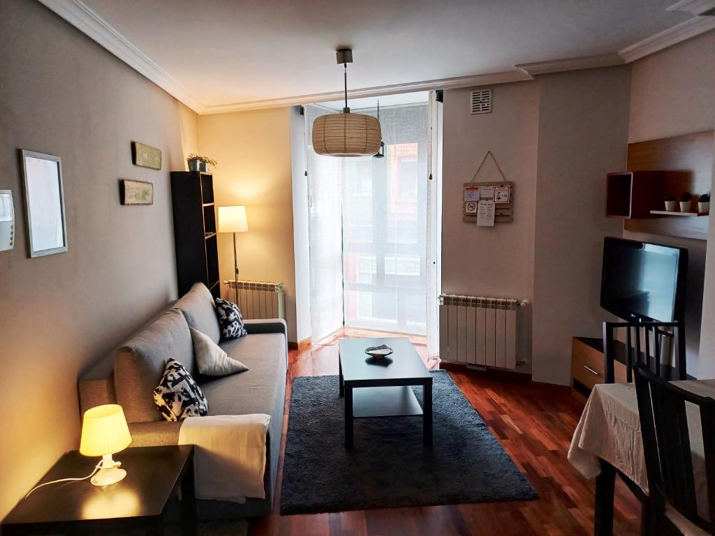 ein Wohnzimmer mit einem Sofa und einem Tisch in der Unterkunft Apartamento Galería Gijón in Gijón