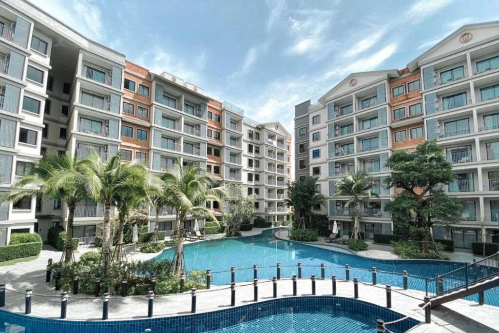 um complexo de apartamentos com piscina e palmeiras em 2 Bedroom Apartment in Naiyang - The Title Residences, Naiyang em Praia de Nai Yang