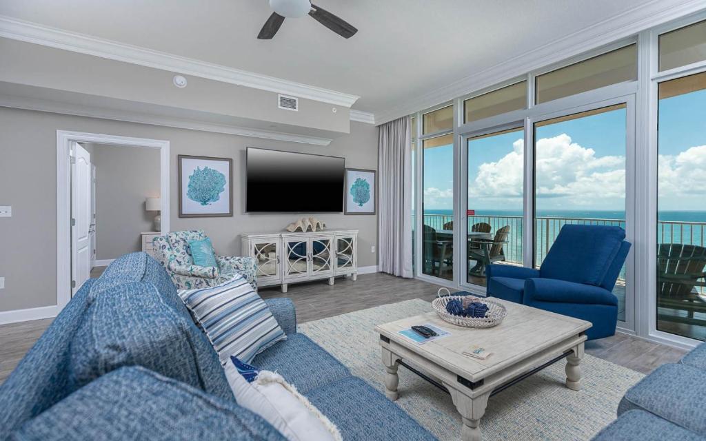 a living room with a blue couch and a tv at Phoenix Orange Beach II 1202 condo in Orange Beach