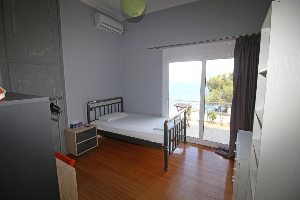 a bedroom with a bed and a large window at Sweet home in Aigio in Aigio