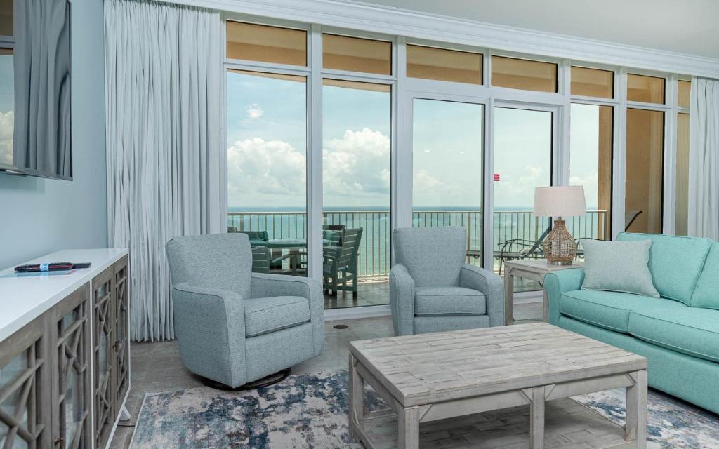 a living room with a couch and chairs and a balcony at Phoenix Orange Beach II 1103 condo in Orange Beach