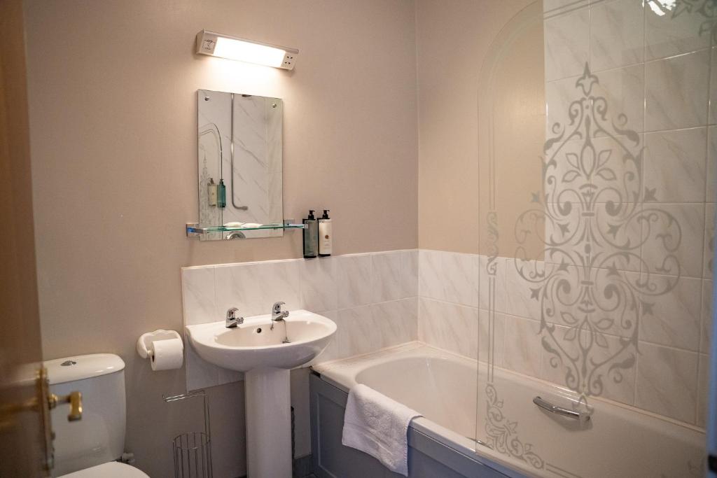 a bathroom with a sink and a tub and a toilet at The Briers Country House in Newcastle