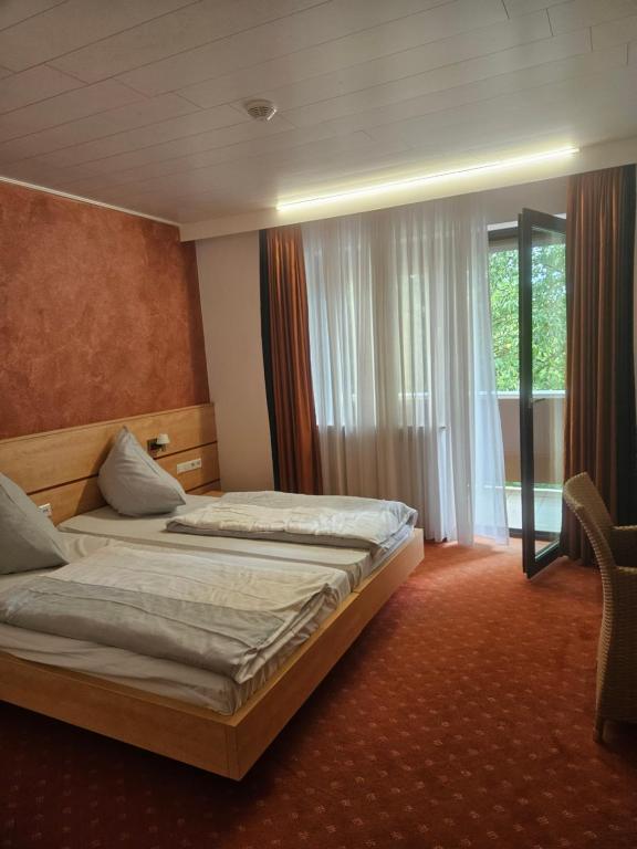 a hotel room with two beds and a window at Terra Ventura Hotel in Gondorf