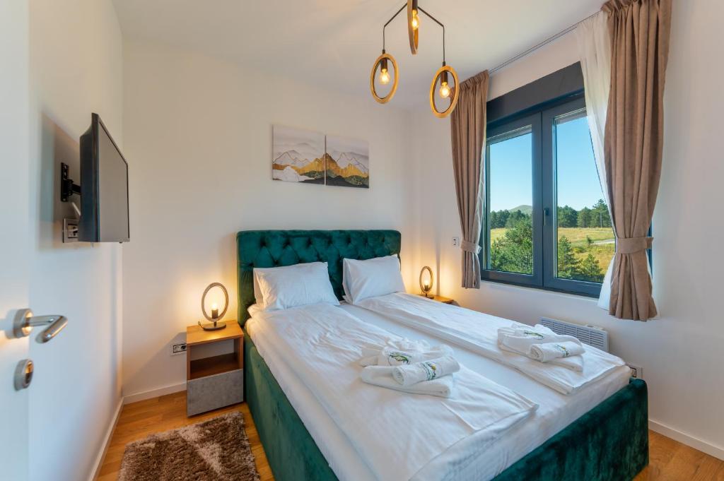 um quarto com uma cama grande e uma janela em Zlatibor Pine View em Zlatibor