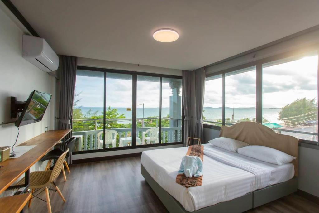 um quarto com uma cama, uma secretária e janelas em Pimpimarn Hotel em Mae Pim