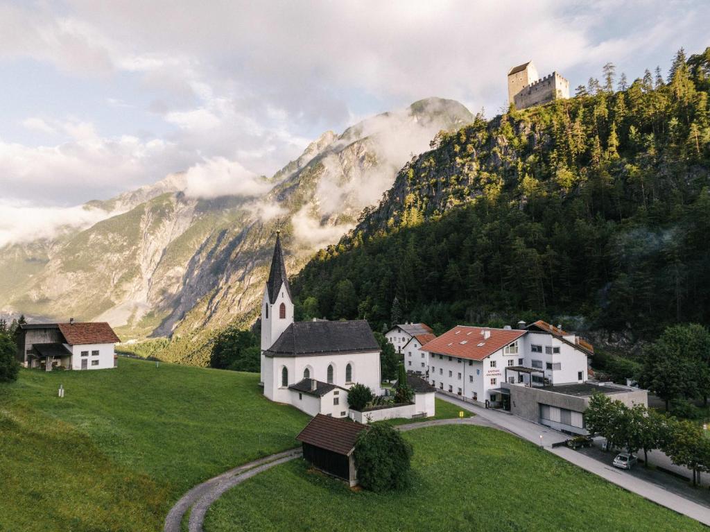 a village with a church and a mountain at Gasthof Kronburg in Zams