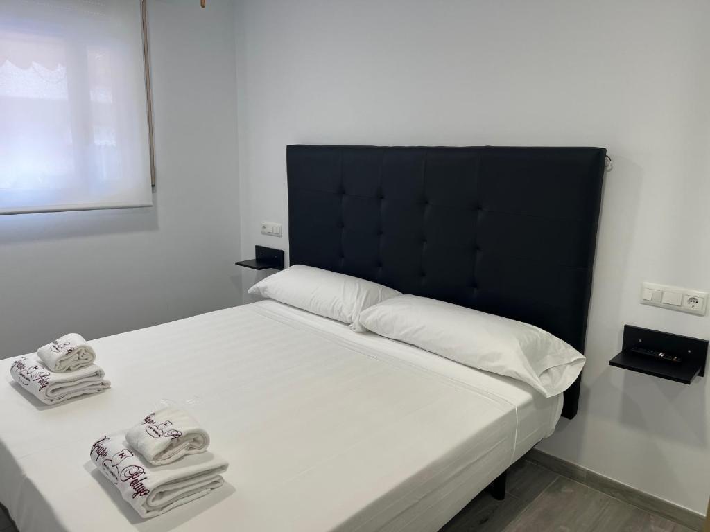 a bedroom with a bed with two towels on it at H Pelayo Auto Check-In Rooms in Noja