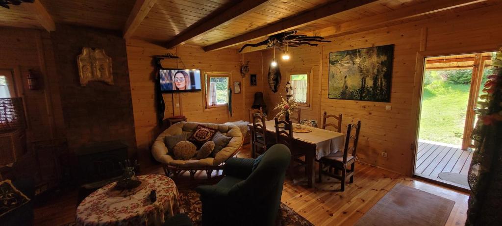 a living room of a log cabin with a table and chairs at Pod Magnolią in Targanice