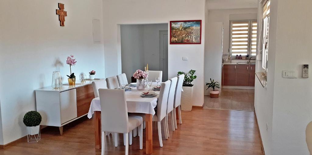 a dining room with a white table and white chairs at Spacious, comfortable and peaceful house in Međugorje