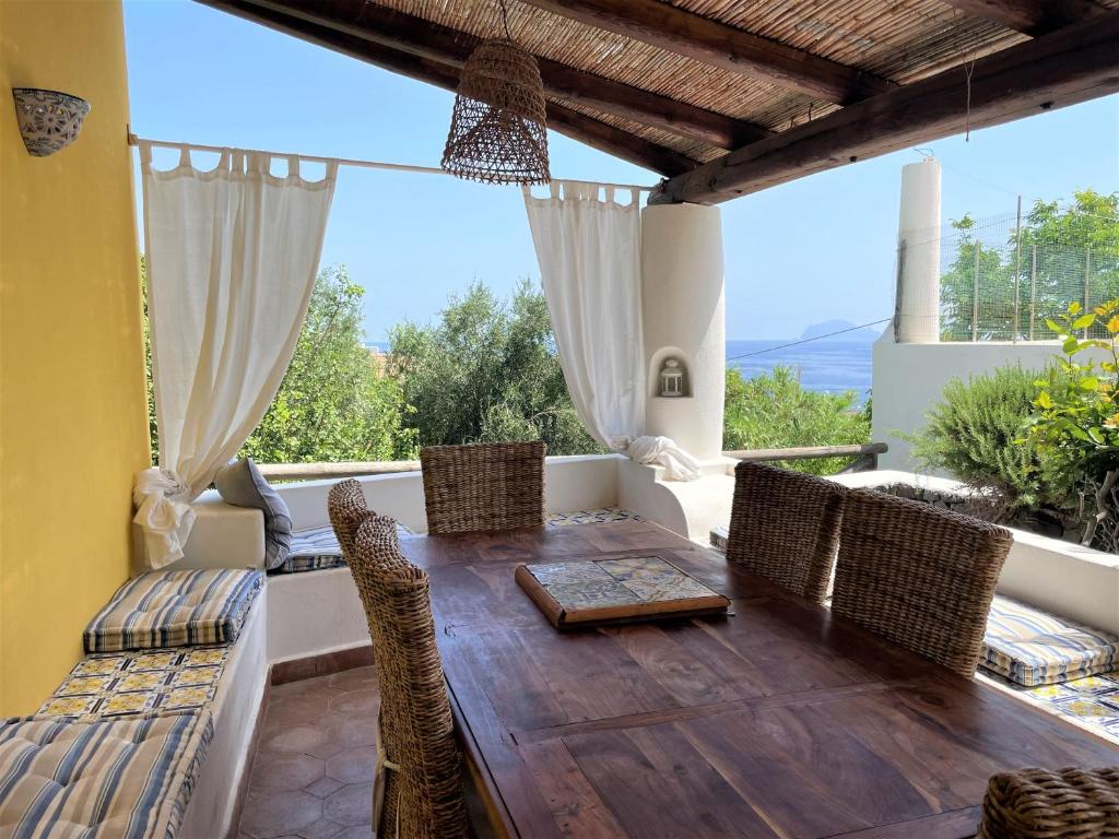 comedor con mesa de madera y sillas en La Casa sul Porto di Santa Marina - Isole Eolie, en Santa Marina Salina