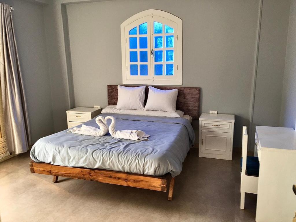 una camera da letto con due cigni sdraiati su un letto di Villa Elkoumy Apartments a Luxor