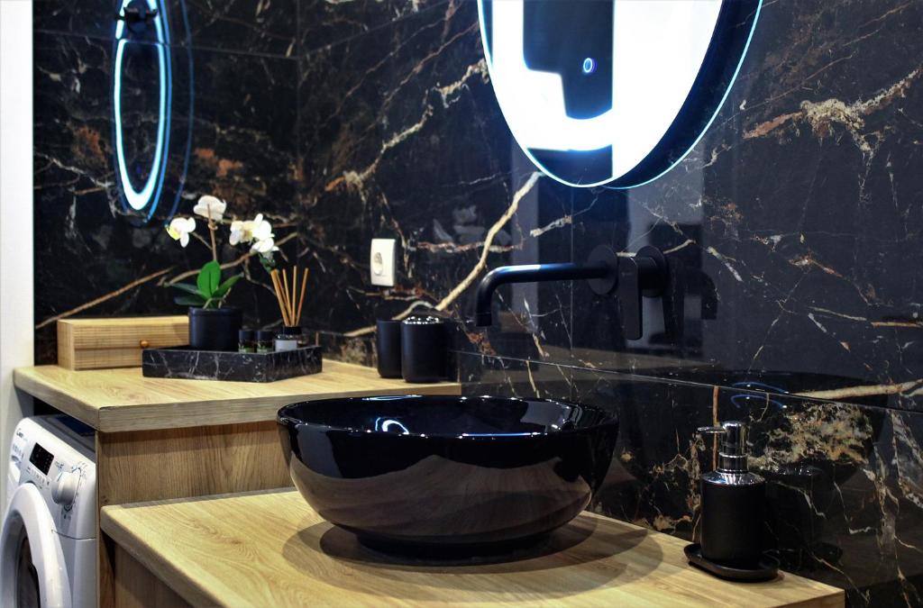 a bathroom with a black bowl sink and a mirror at Neo Luxury Suite in Athens