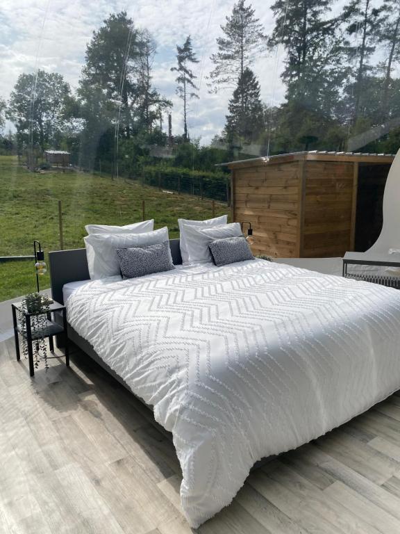 ein großes weißes Bett auf einer Terrasse in der Unterkunft La bulle du Bon'Heure in Somme-Leuze
