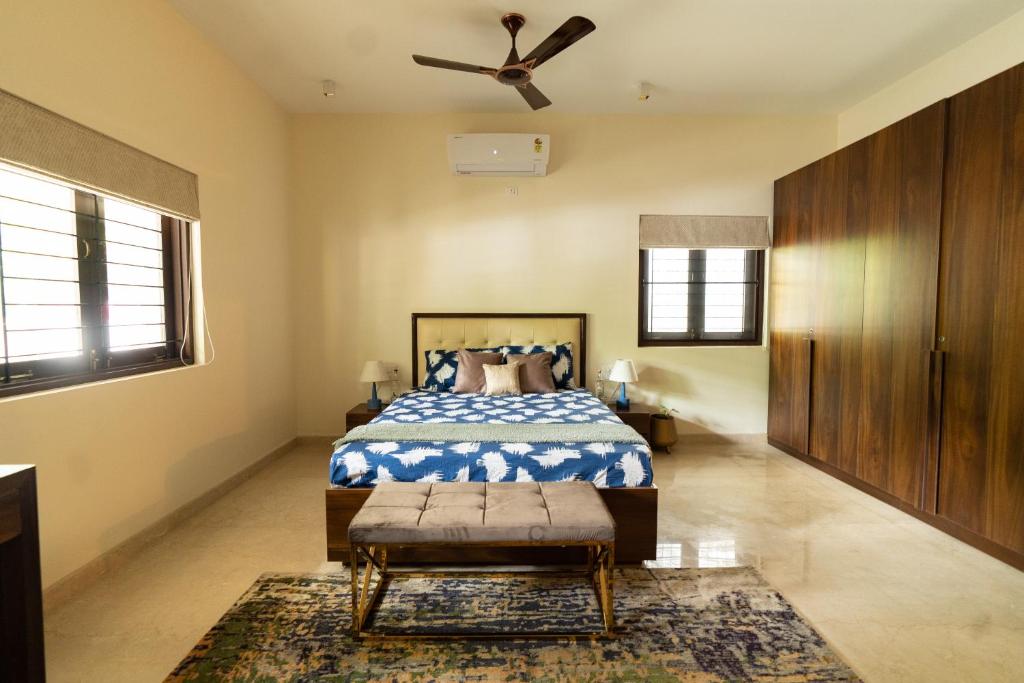 a bedroom with a bed and a ceiling fan at Luho 125 in Bangalore