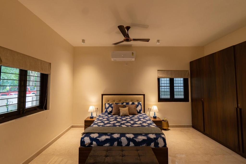 a bedroom with a bed and a ceiling fan at Luho 125 in Bangalore