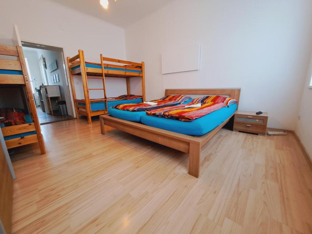 een slaapkamer met 2 stapelbedden en een houten vloer bij Relax Appartement 10 minutes to downtown in Wenen