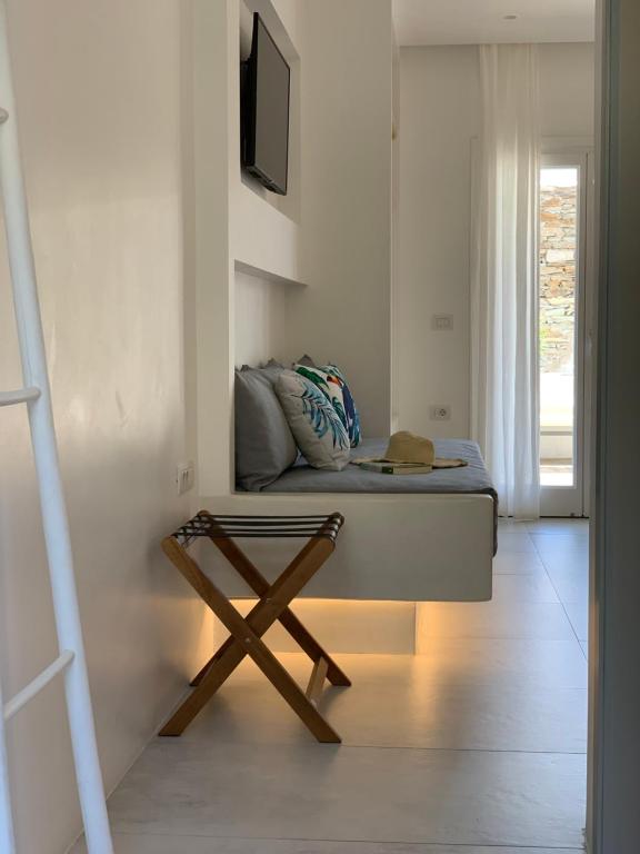 a room with a couch and a tv on a wall at Ios Art Suites in Ios Chora