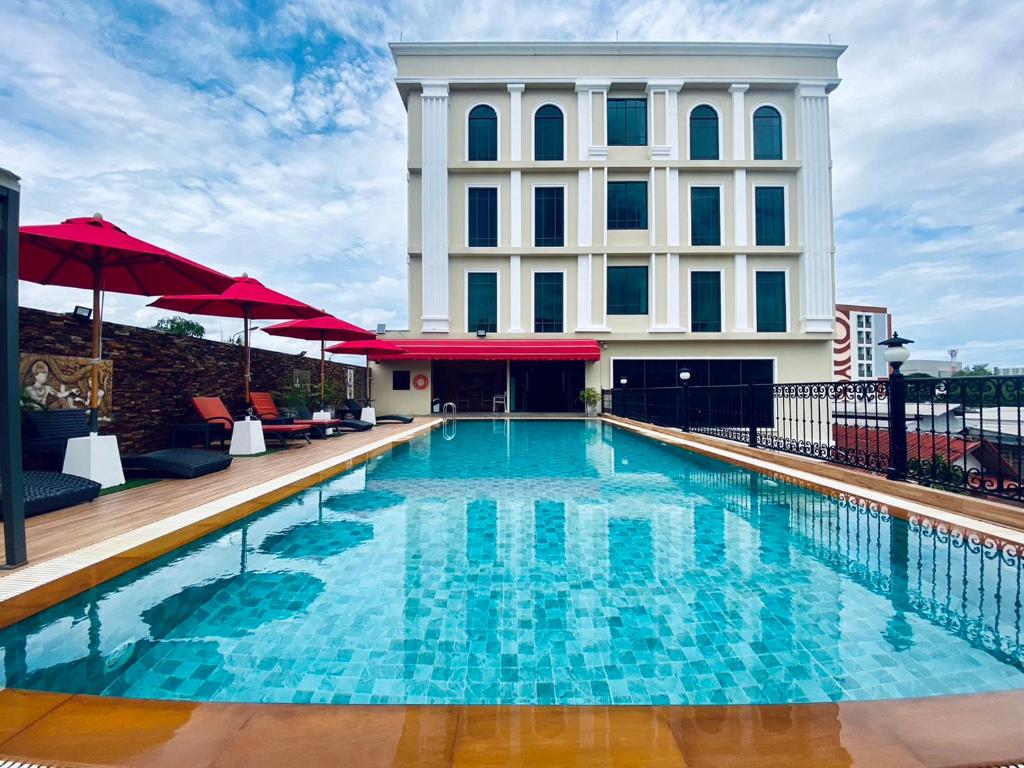 a swimming pool in front of a building at Banbua Grand Udon in Udon Thani