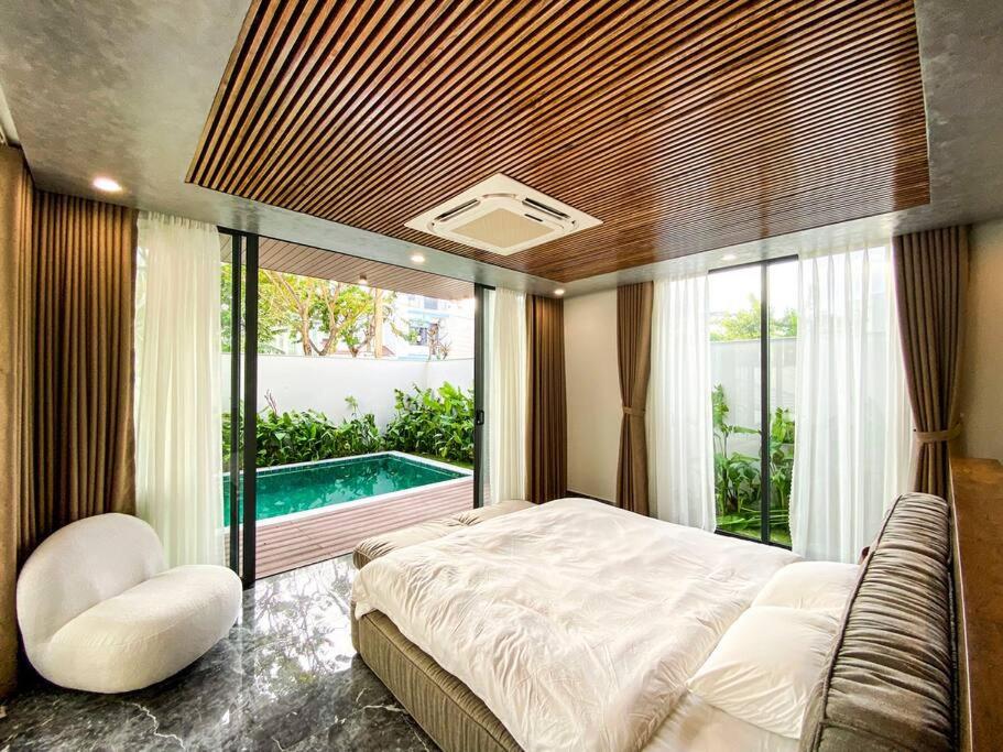 a bedroom with a large bed and a swimming pool at Song Cat Villa 59NL in Danang