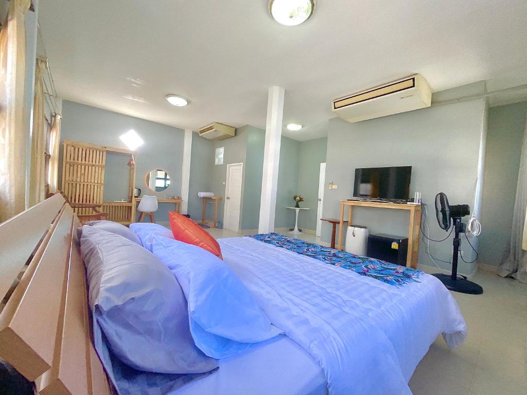 a bedroom with a large bed with blue sheets and pillows at Private room in Central Pattaya Naeem House in Nong Prue