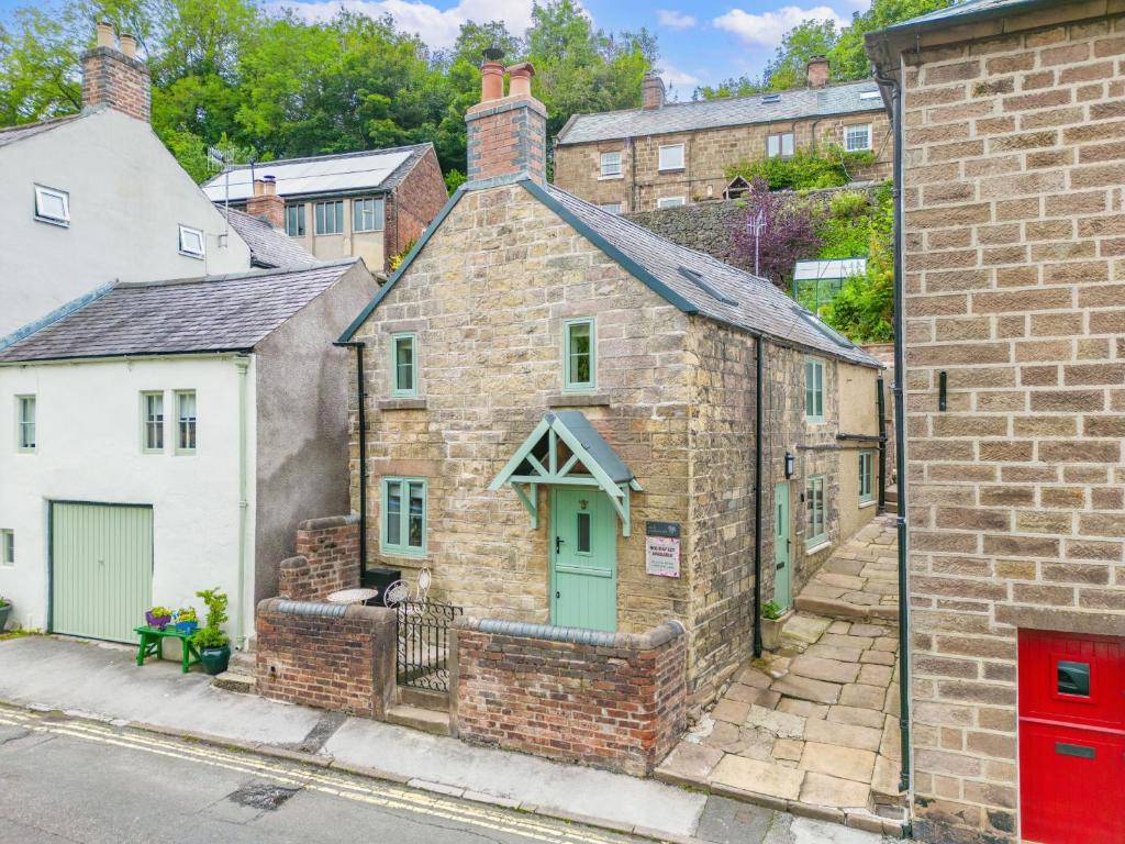 an old brick building with green doors in a city at 1 Promenade View in Cromford
