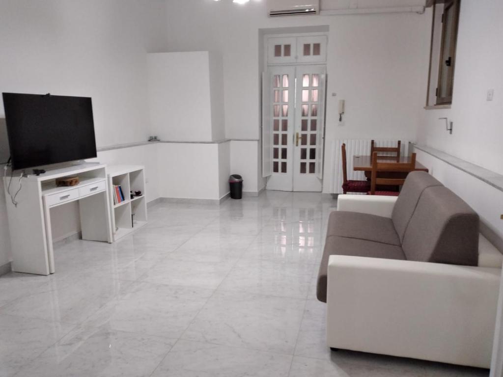 een woonkamer met een bank en een tv bij Casa Maestrina in Benevento