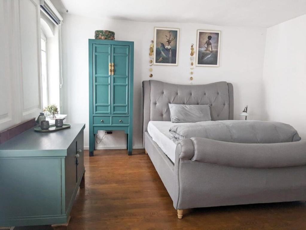a bedroom with a bed and a blue cabinet at Kleine Villa - ganzes Stadthäuschen für Gruppen Familien oder nur zu Zweit in Bamberg